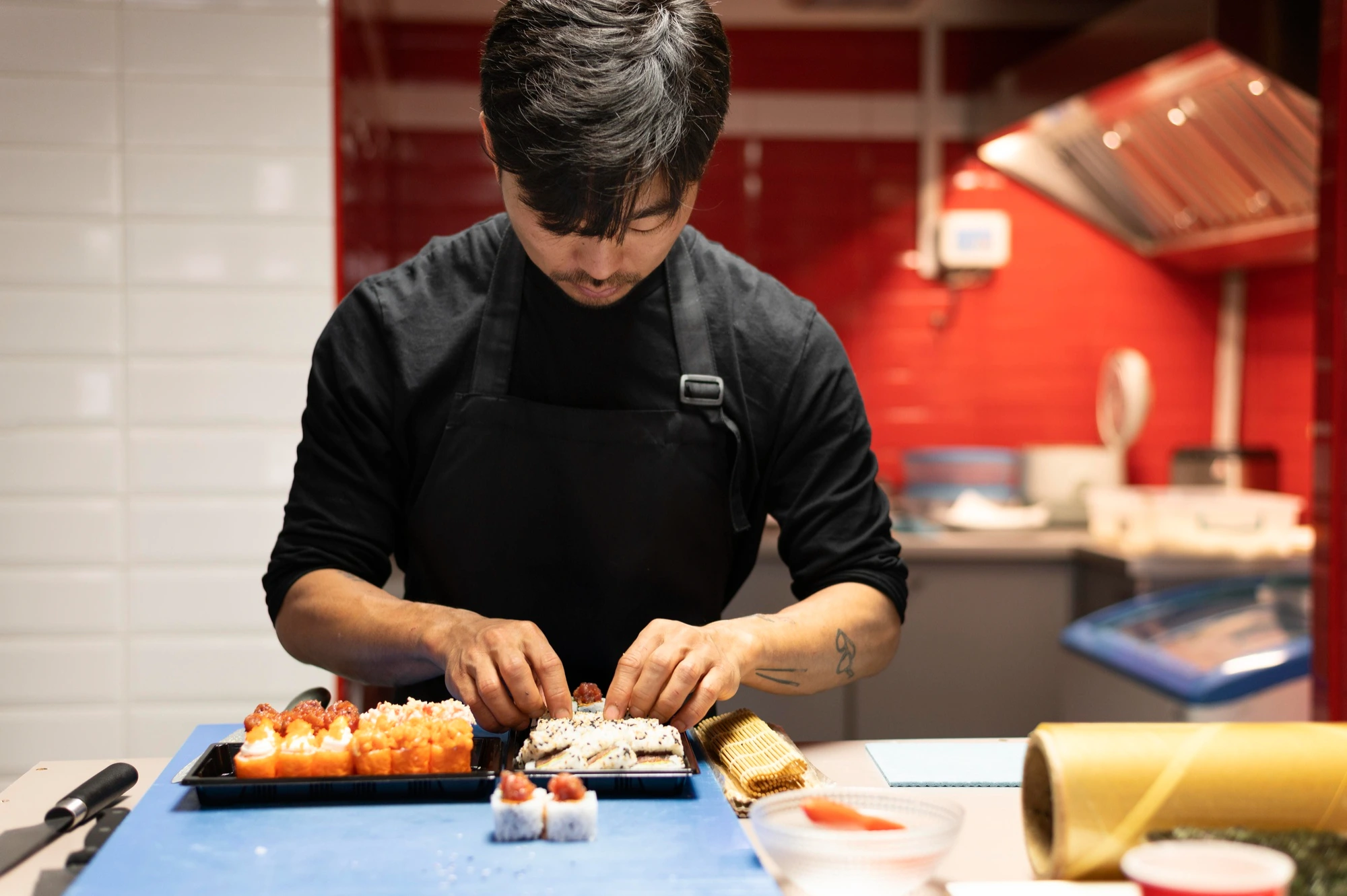 Sushi chef hand-rolling fresh sushi